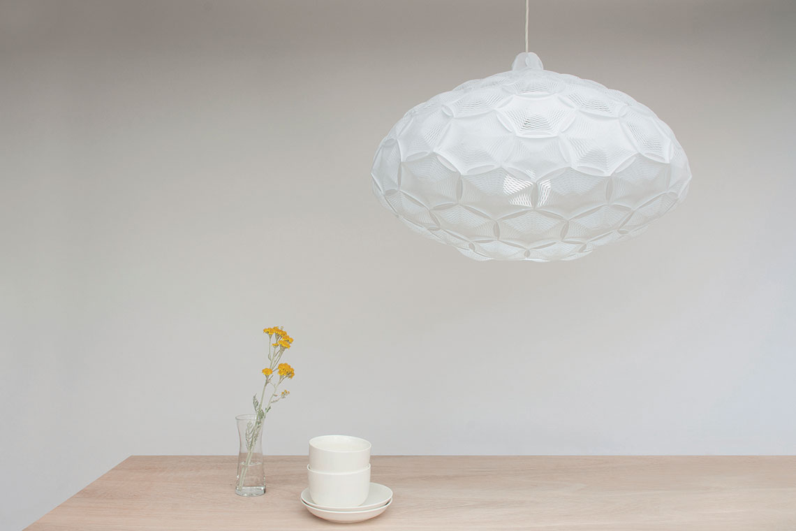 large cloud like white Airy pendant lamp designed by 24d-studio hangs over a wood dining table