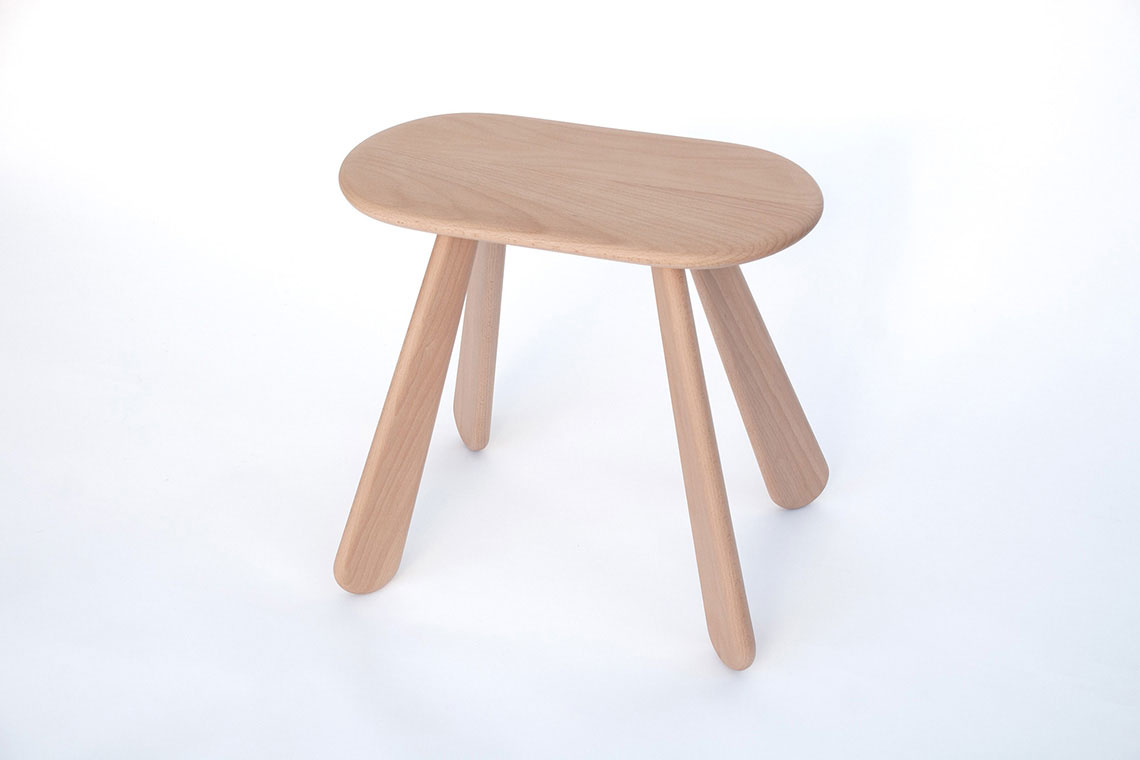 Atlas wood stool has an oval soft edge seat and supported by four sculptural legs, a perfect and comfortable seat for one